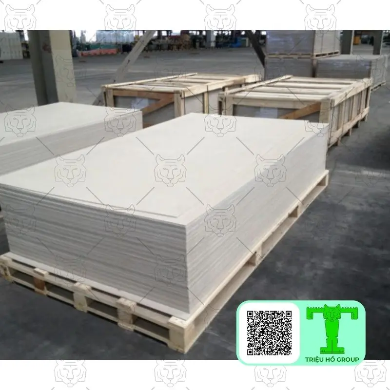 Các chồng tấm smartboard màu trắng được xếp trên pallet gỗ trong nhà kho
