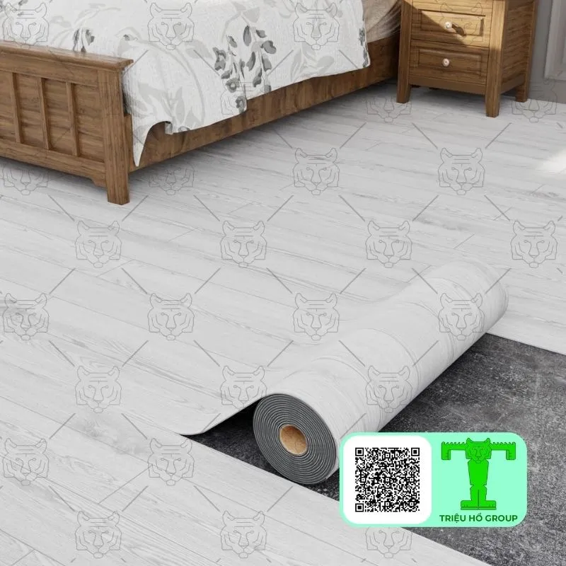 Cuộn sàn nhựa vinyl vân gỗ màu trắng xám đang được trải trên nền phòng ngủ, một phần sàn đã hoàn thiện