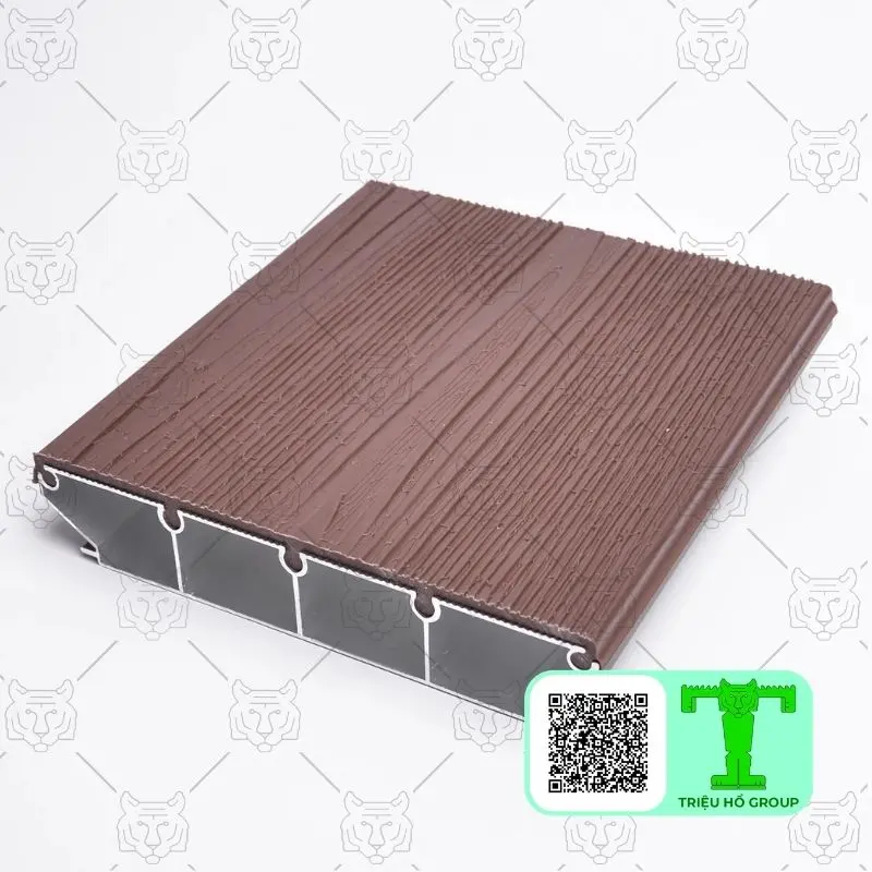 Tấm sàn nhựa màu nâu vân gỗ với mặt cắt ngang lộ rõ cấu trúc rỗng nhiều khoang bên trong