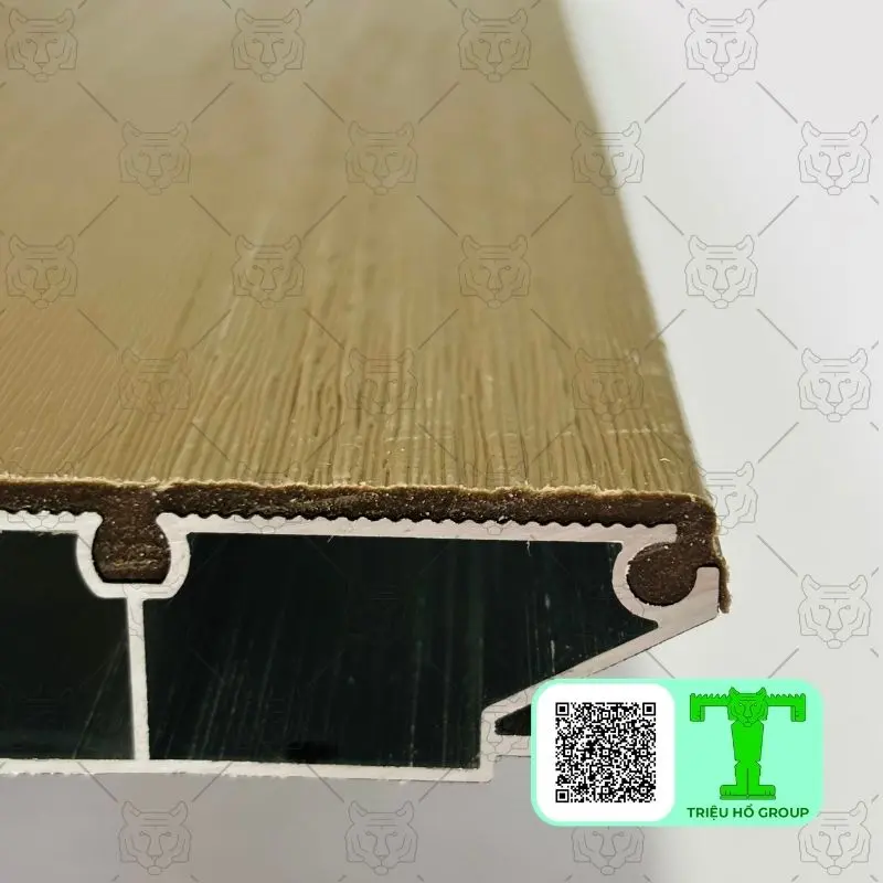 Mặt cắt ngang của tấm sàn nhựa lõi nhôm màu be, cho thấy cấu trúc lõi hợp kim với các khoang rỗng bên trong