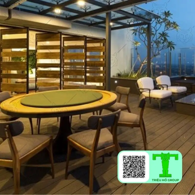 Sàn gỗ Conwood tối màu trên sân thượng với bàn ăn hình bầu dục và ghế gỗ, cùng khu vực ghế sofa ngoài trời