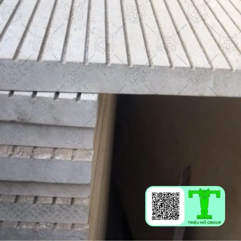 Các tấm sàn gỗ ngoài trời Conwood màu xám nhạt với bề mặt có rãnh, được xếp chồng lên nhau