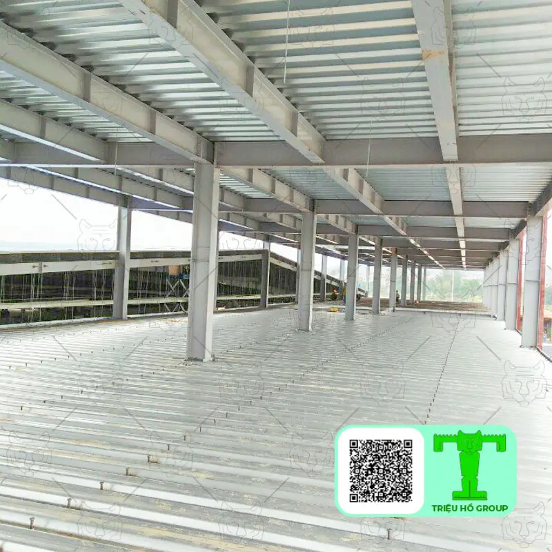 Cấu trúc khung thép của một tòa nhà đang xây dựng với các tấm sàn deck kim loại và dầm thép