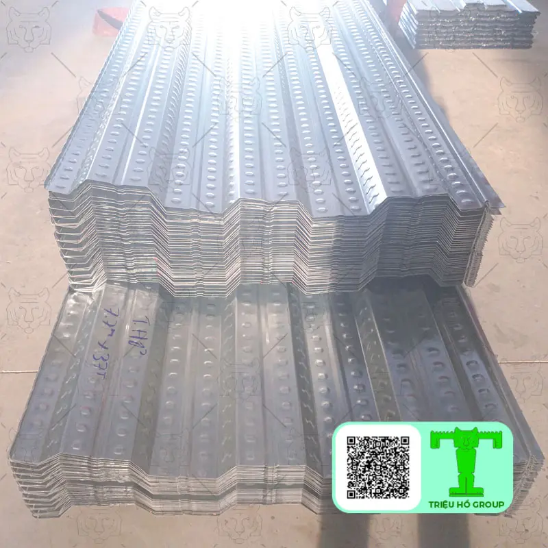 Các chồng tấm sàn deck kim loại có gân nổi được xếp gọn gàng, sẵn sàng cho việc lắp đặt trong xây dựng