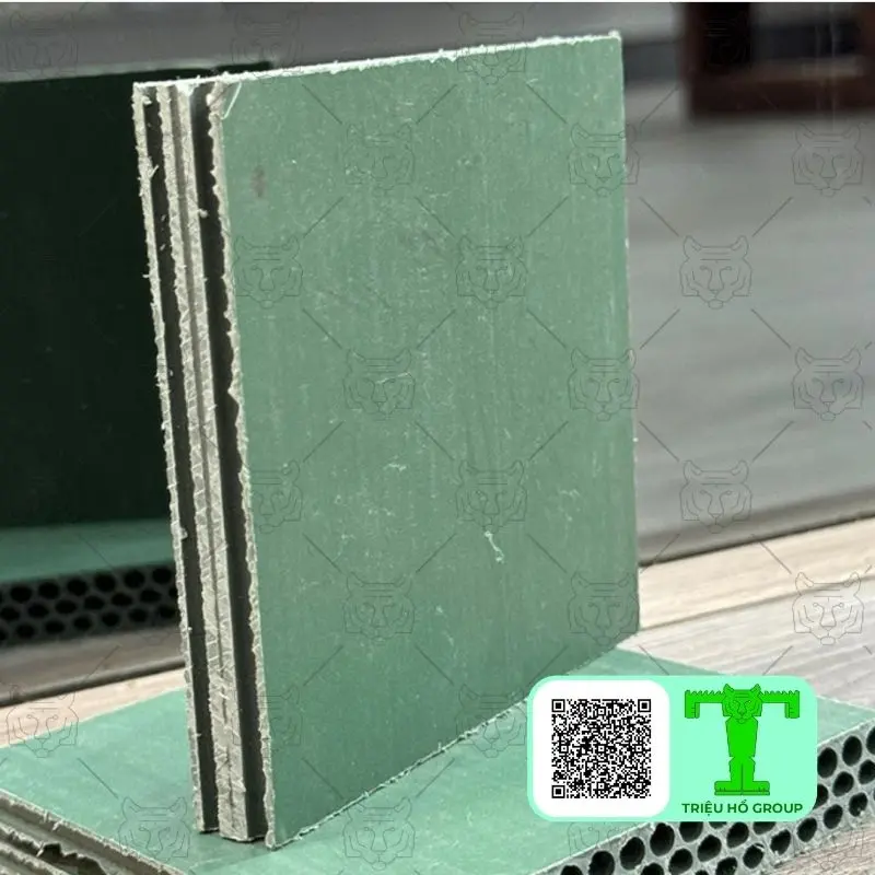 Hai tấm ván nhựa cốp pha màu xanh lá cây, một tấm đứng thẳng lộ cạnh nhiều lớp và một tấm nằm ngang lộ lõi rỗng