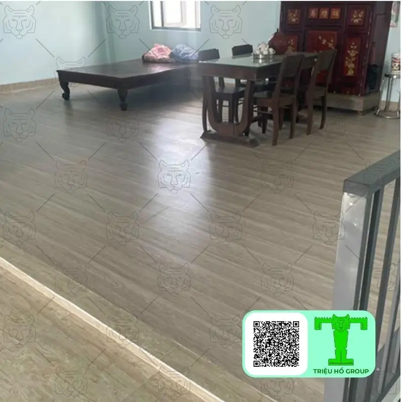 Sàn nhà lát ván nhựa PVC màu vân gỗ nhạt trong không gian phòng có giường và bàn ăn